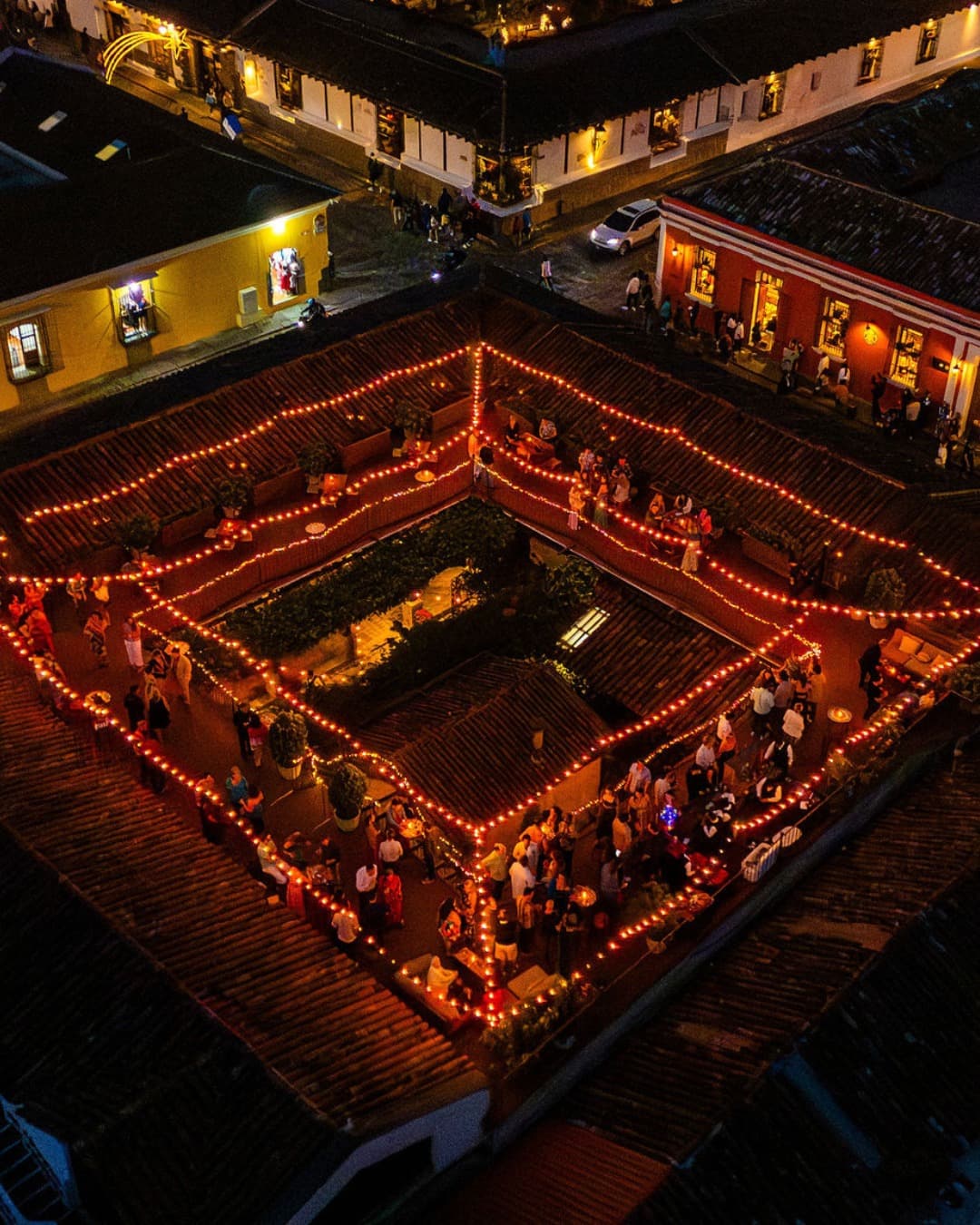 Casa Troccoli's colonial courtyard at night, seen from above and ringed with warm lights.